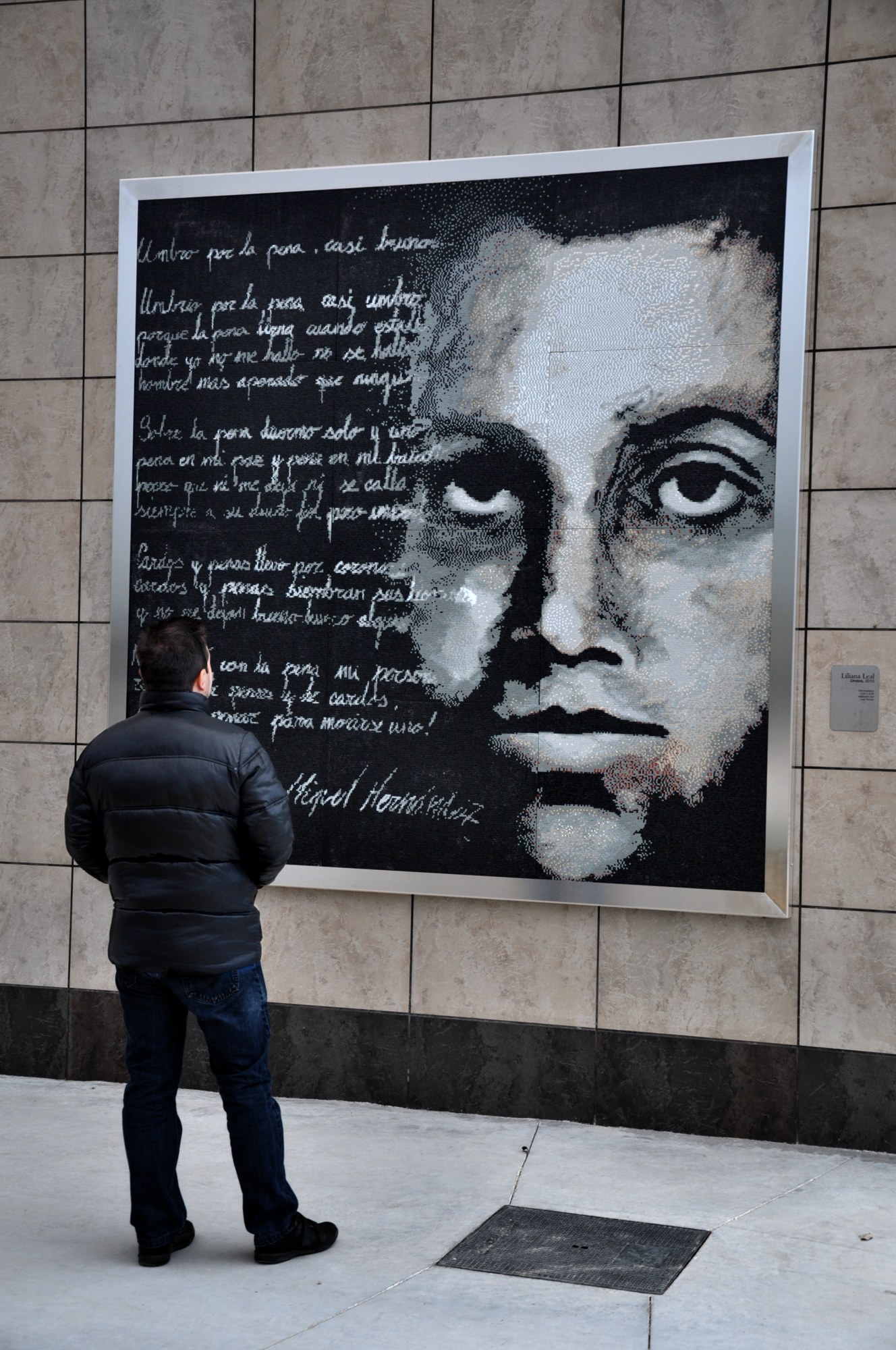 Mural de Miguel Hernández con una persona que muestra su escala